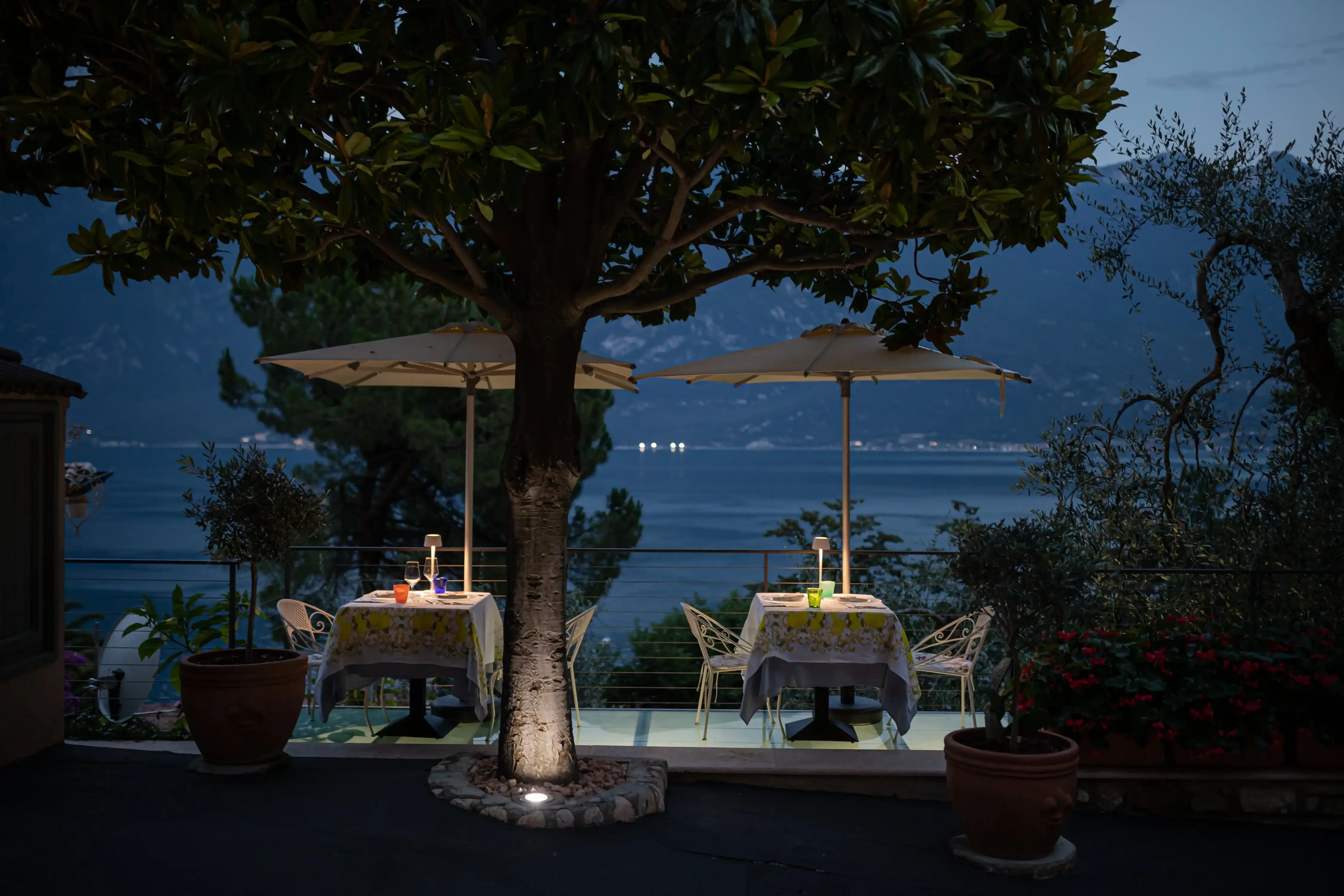 Abendessen auf Terrasse mit Seeblick unter Sonnenschirmen