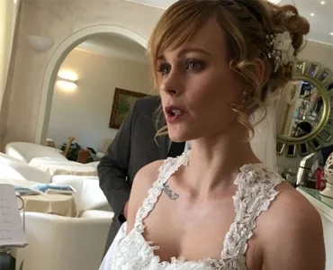Braut im weißen Kleid spricht in elegantem Wohnzimmer