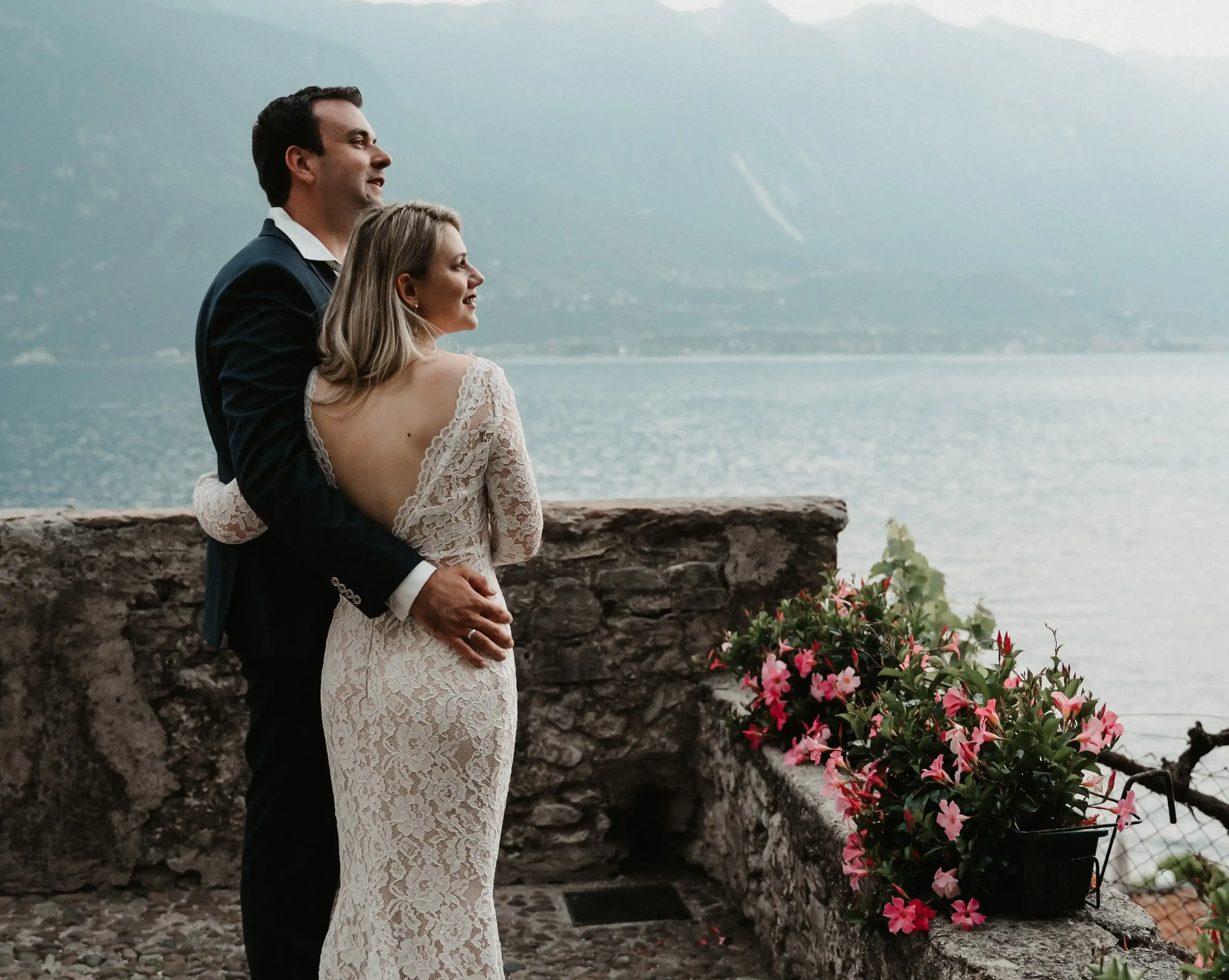 Brautpaar umarmt sich mit Blick auf den See