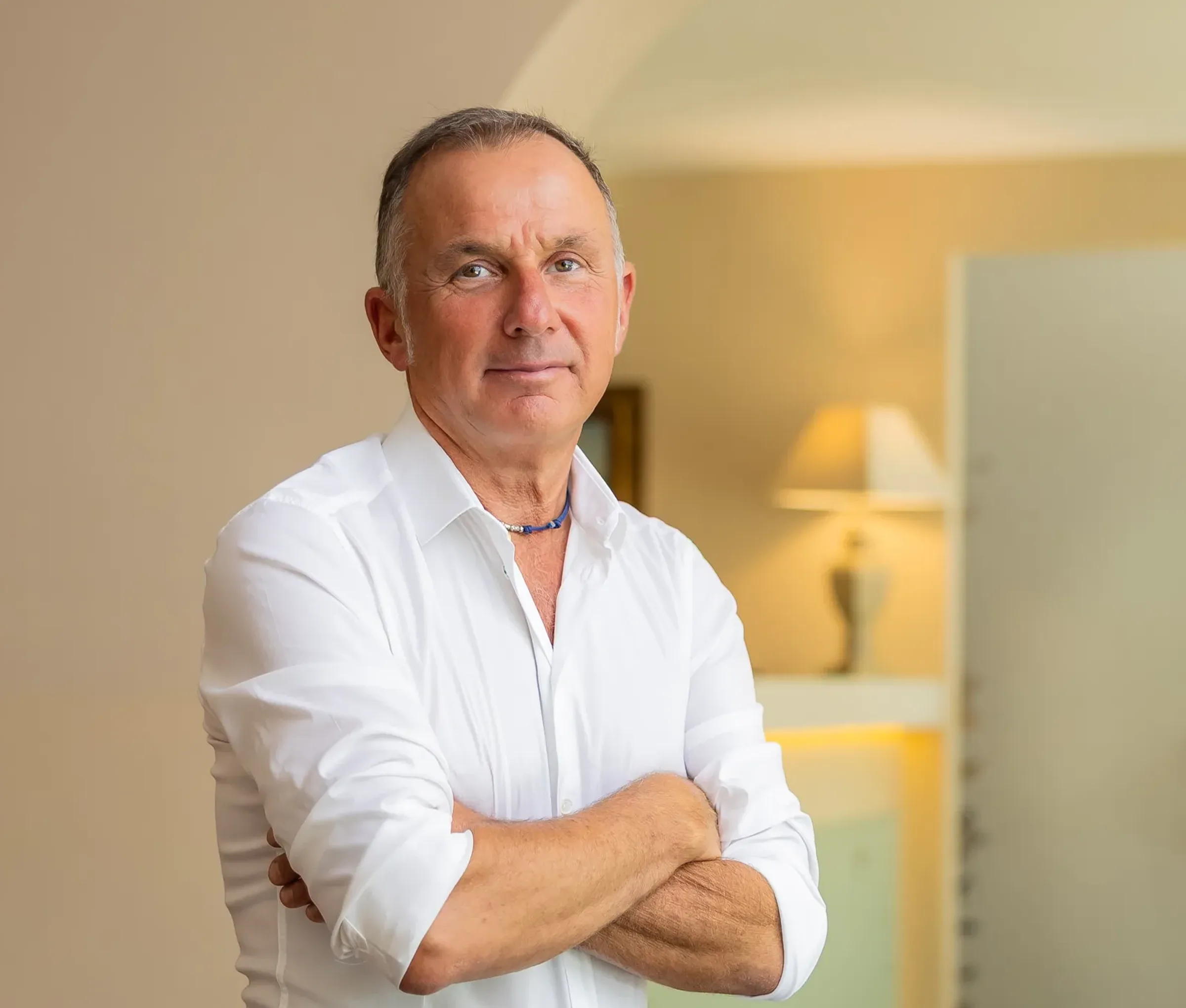 Confident middle-aged man in white shirt at home