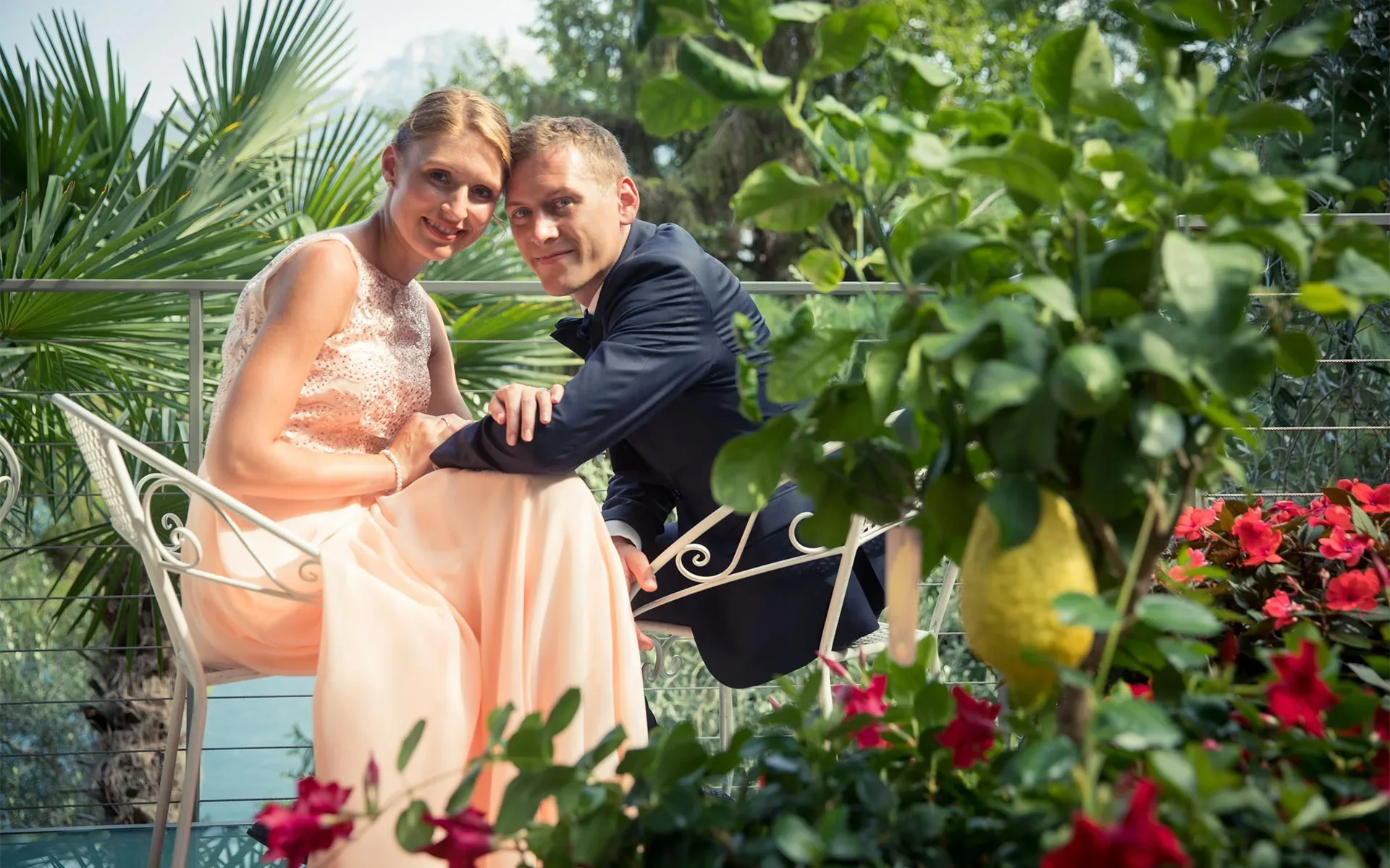 Elegantes Paar posiert im Garten mit tropischen Pflanzen