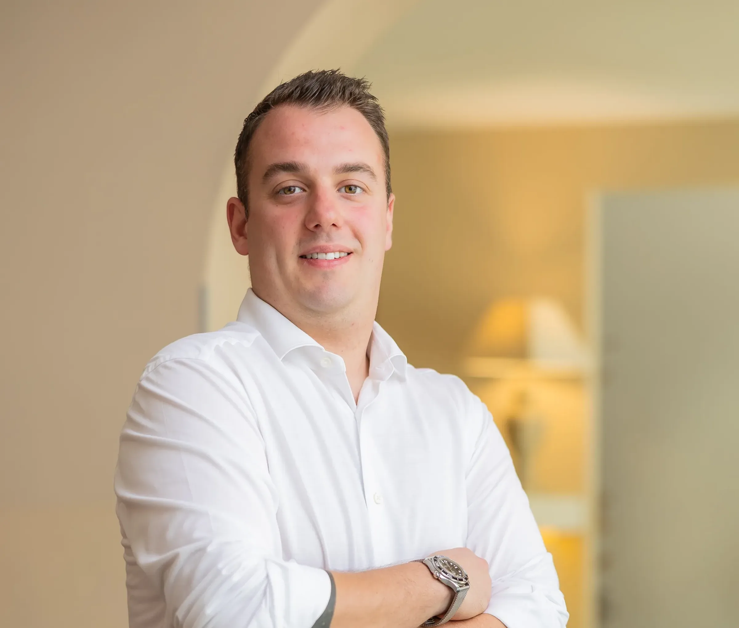 Lachender Mann im weißen Hemd mit verschränkten Armen